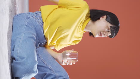 Vertical-video-of-Young-woman-drinking-water-for-healthy-life.